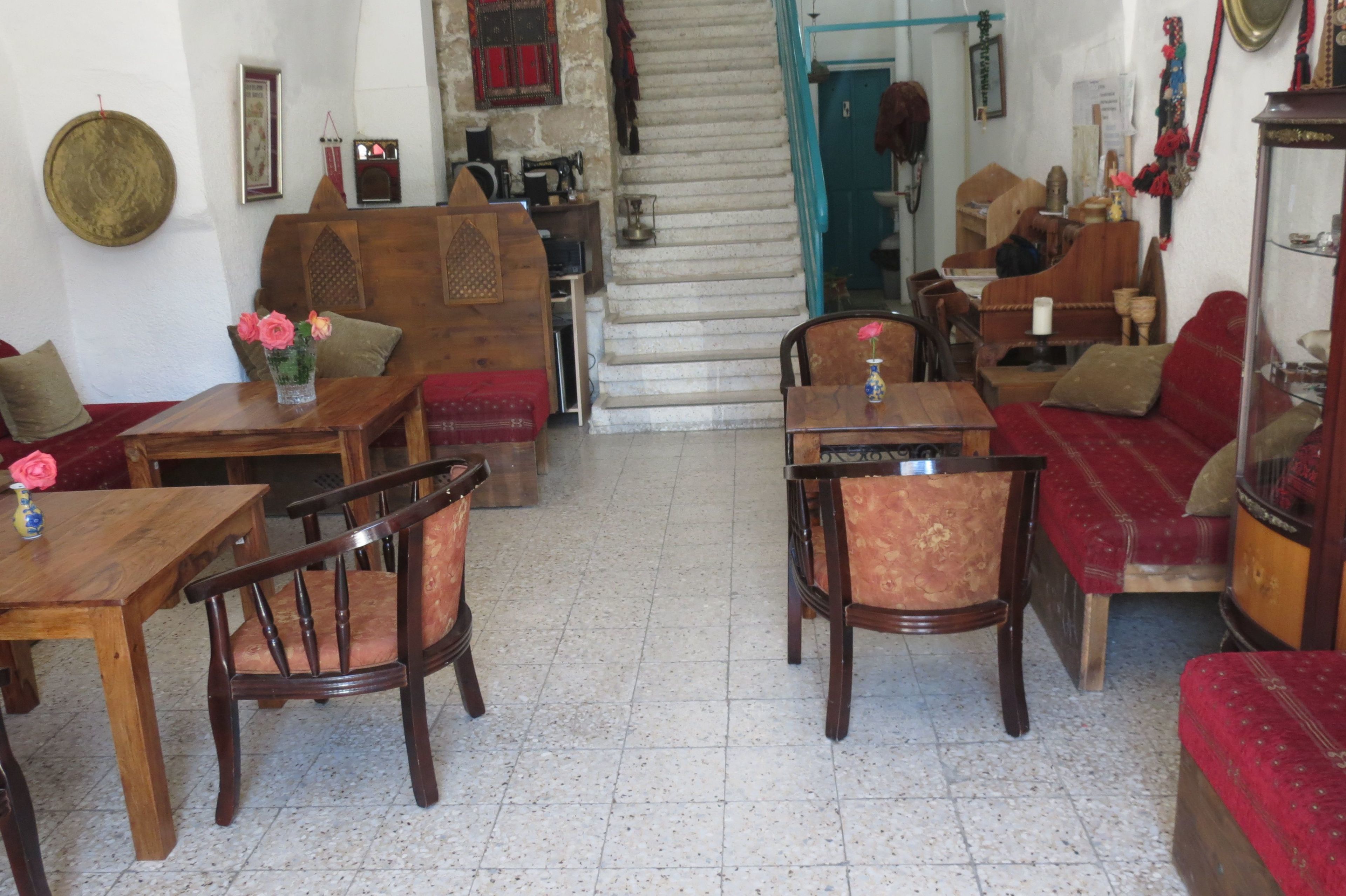 A traditional room with a wooden sofa, a wooden table, and a chair. There is a staircase leading to another room.