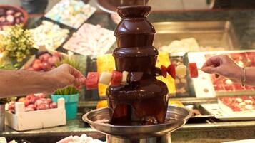 Una fuente de chocolate con brochetas de fresas y malvaviscos.