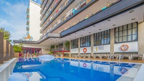 Ein Hotel mit Schwimmbad, mehreren Balkonen und Sitzgelegenheiten im Freien.