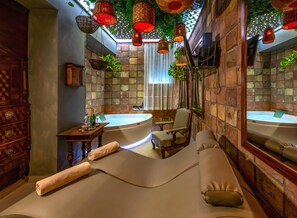 A spa room with a large bathtub, a massage table, and hanging red lanterns. - Hotel Szárcsa (Szekesfehervar)