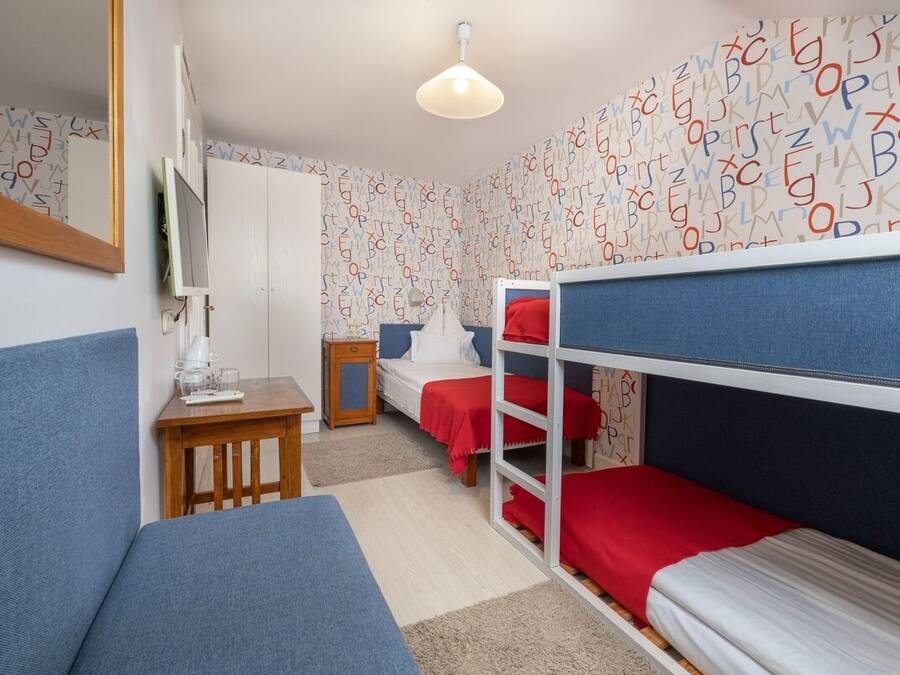 Et værelse med køjesenge, et skrivebord, en stol og et spejl.