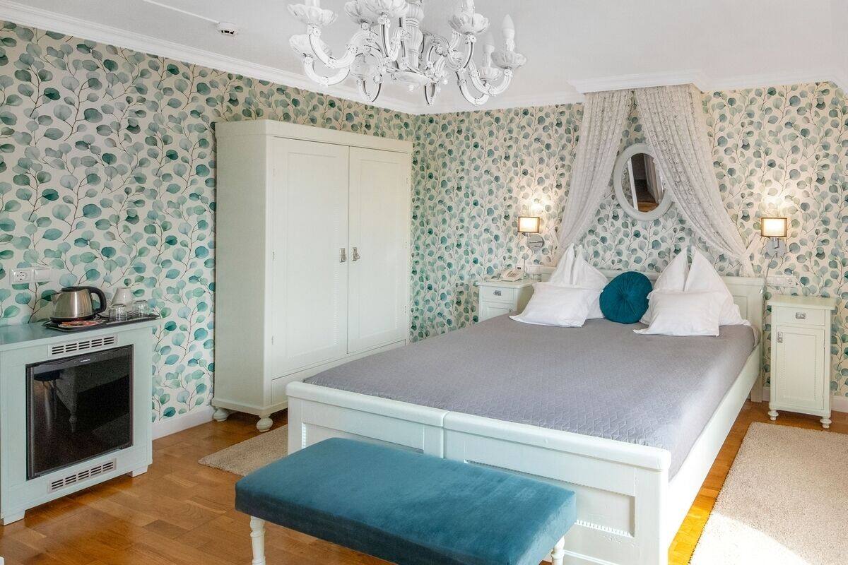 Ein Schlafzimmer mit Bett, Kleiderschrank, Nachttisch, Lampe und Fernseher.