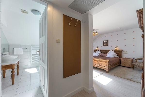 A bedroom with a bed, bedside tables, and a nightstand. - Hotel Szárcsa (Szekesfehervar)