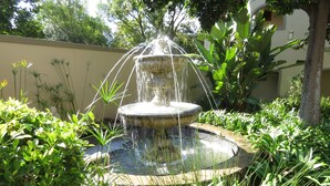 Une fontaine entourée d’une végétation luxuriante.