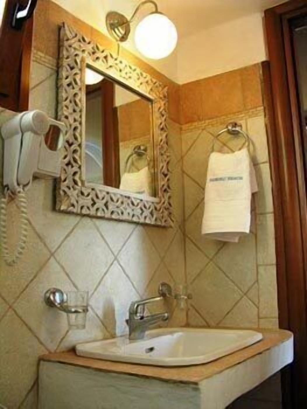 Une salle de bain équipée d’un lavabo, d’un miroir et d’un porte-serviettes.