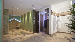 A modern bathroom with a glass shower enclosure, a wooden vanity, and a potted plant. - Hotel Arnika (Oberammergau)