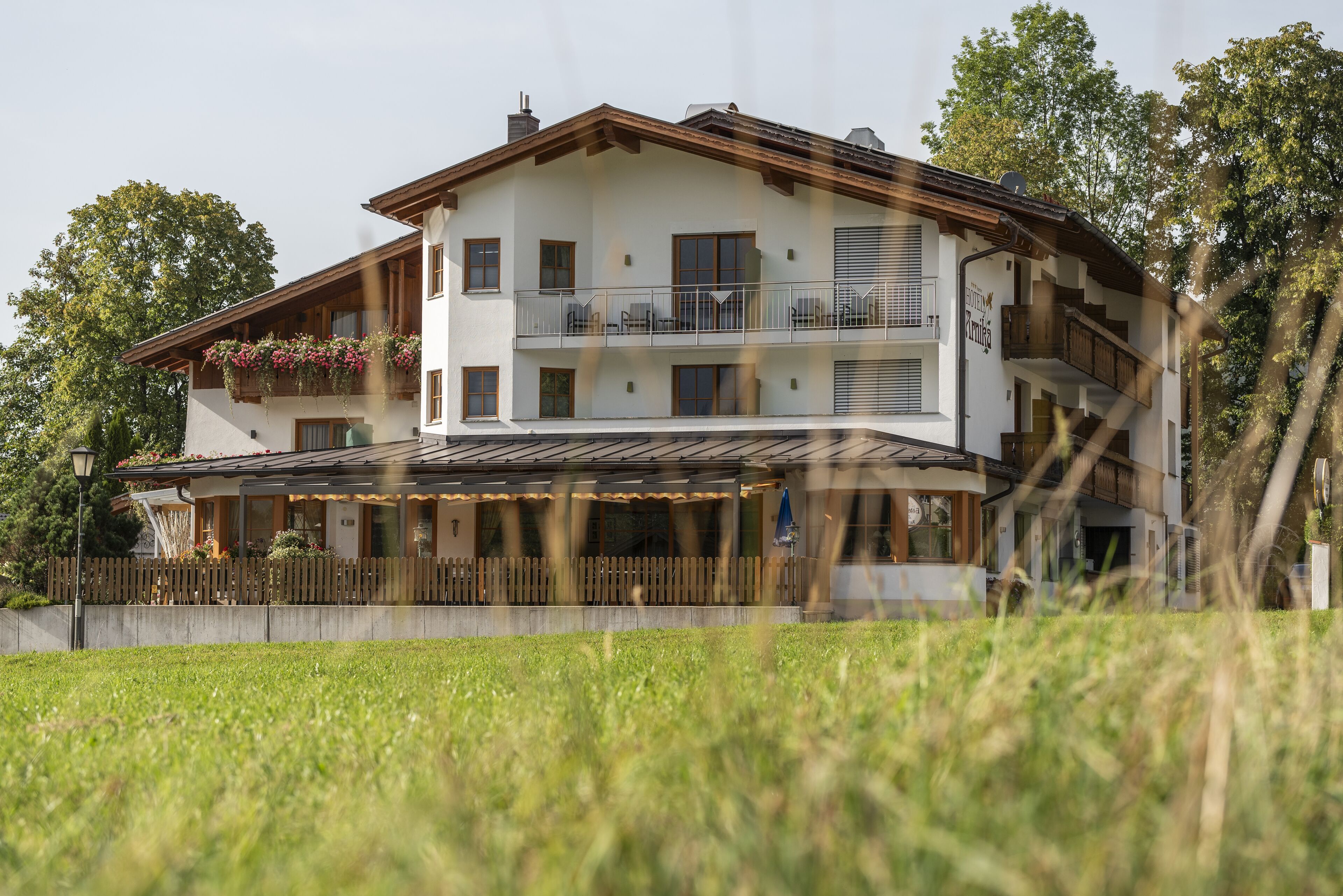 A two-story building with a balcony, a covered patio area, and a wooden fence.