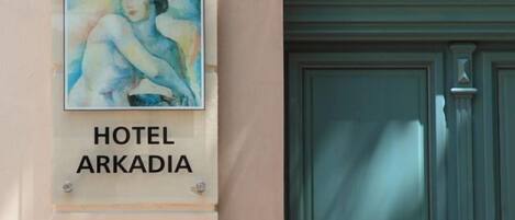 Señal del Hotel Arkadia con una pintura de una mujer.