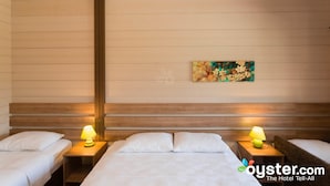 A hotel room with two beds, wooden headboards, and bedside lamps.