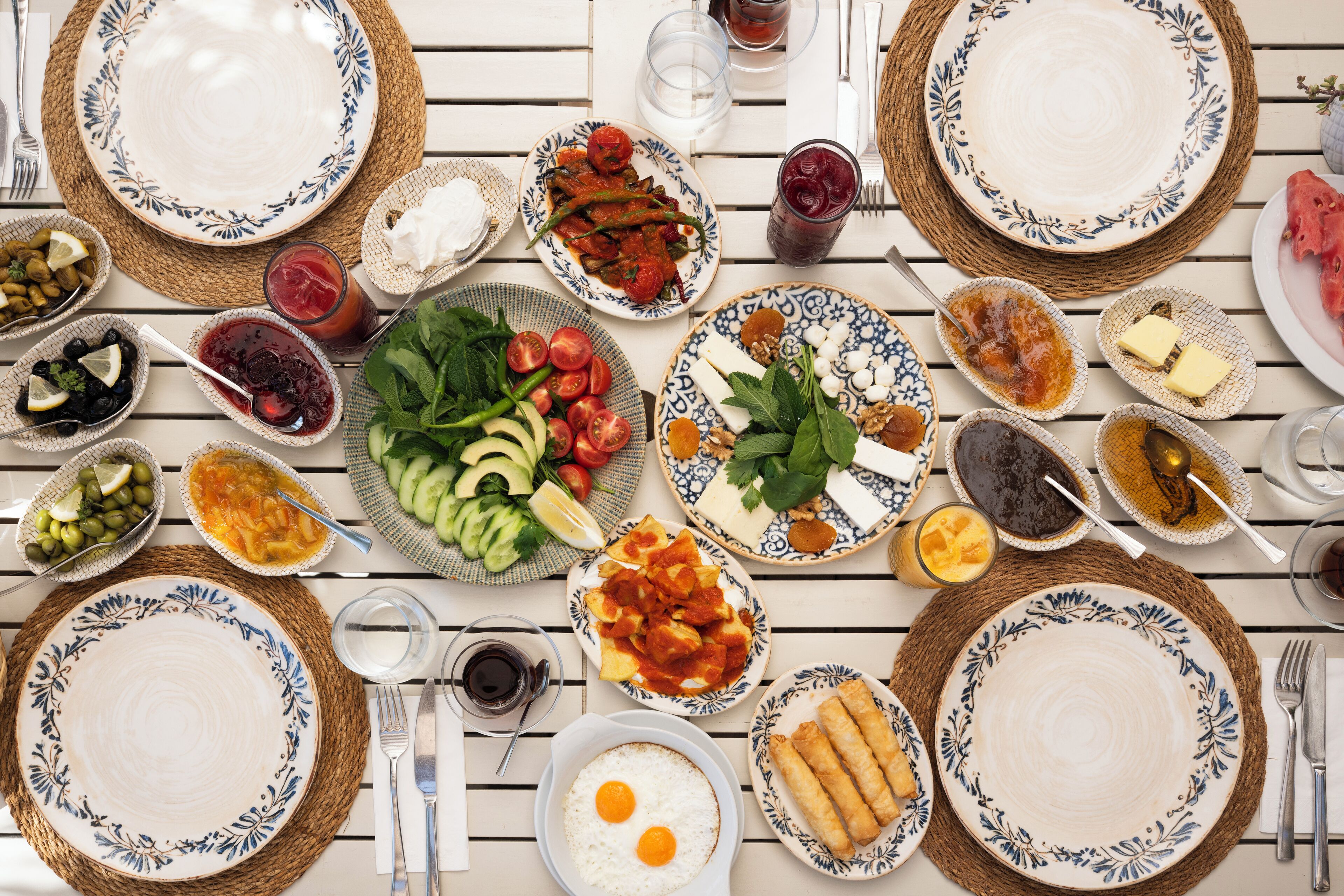 A table set with various dishes, including eggs, vegetables, and sauces, suggesting a meal setting.