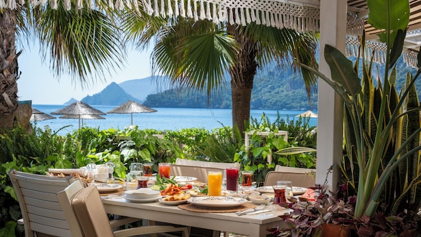 Ein Frühstückstisch mit Blick auf das Meer und die Berge.