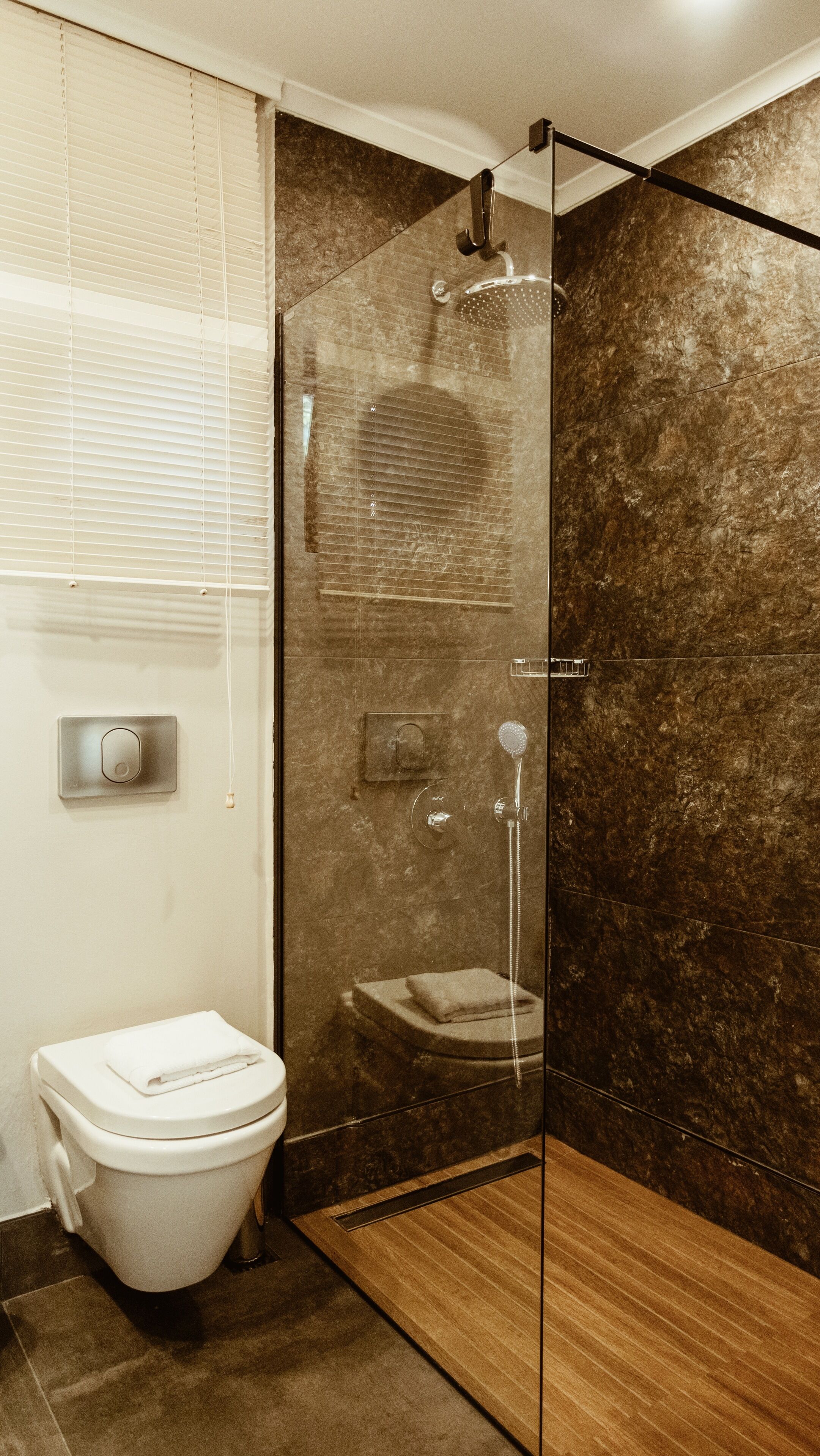 Un baño moderno con cabina de ducha de vidrio, inodoro y lavamanos.