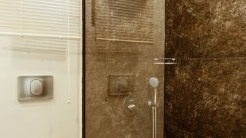 Un baño moderno con cabina de ducha de vidrio, inodoro y lavamanos.