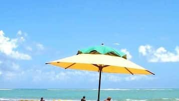 On the beach, white sand, beach umbrellas, beach towels