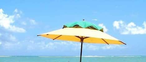 Aan het strand, wit zand, parasols, strandlakens