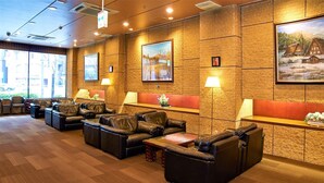 A lobby with leather seating, wooden tables, and framed artwork on the walls. - Toyo Hotel (Fukuoka)