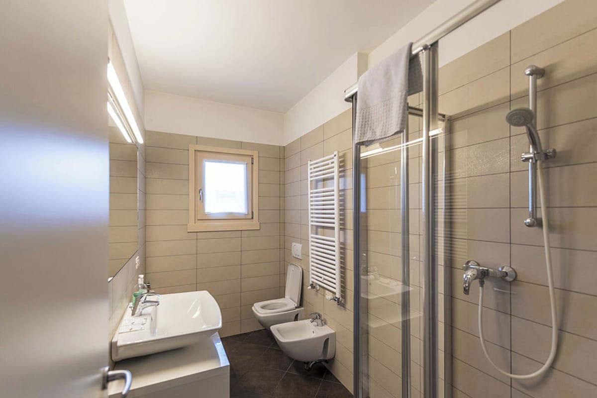 Un baño moderno con ducha, inodoro y lavabo.