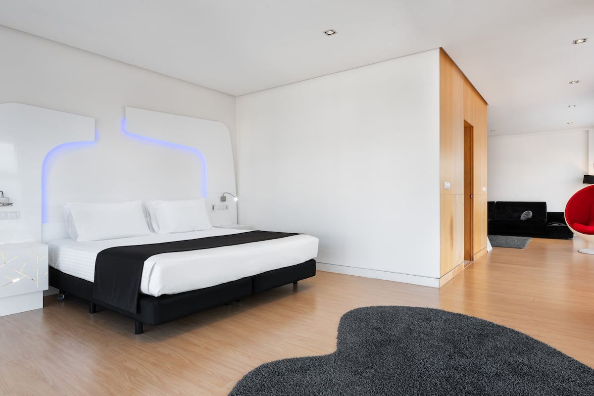 A modern bedroom with a bed, bedside table, and a wardrobe.
