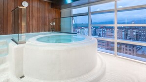 Jacuzzi interior modern amb una vista panoràmica de la ciutat.