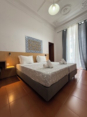 Ein Hotelzimmer mit einem großen Bett, einem Nachttisch, einer Wandleuchte und einer dekorativen Fliese über dem Bett.