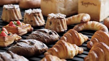 Une variété de viennoiseries et de pains disposés sur un plateau.