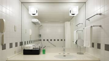 Une salle de bain moderne avec un grand miroir, un lavabo, une douche et des toilettes.