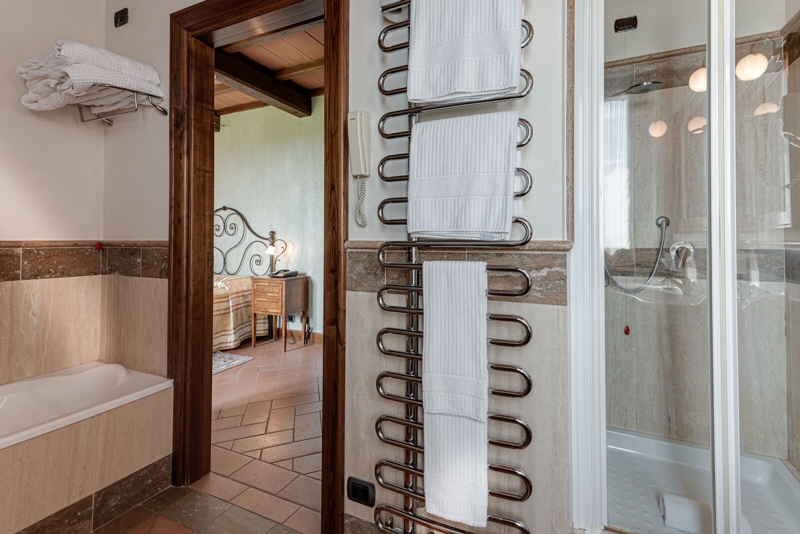 Une salle de bain équipée d’une baignoire, d’une douche et d’un porte-serviettes avec plusieurs serviettes.