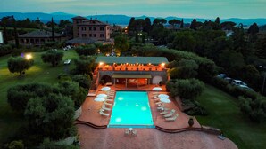 Vista aerea di un resort con piscina, poltrona prendisole e area bar.