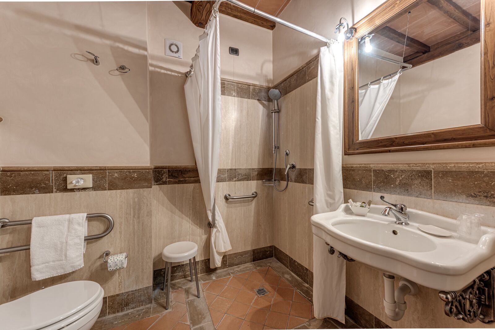 Une salle de bain avec douche, toilettes et lavabo.