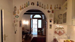 Un intérieur comprenant un couloir menant à une salle à manger, décorée de divers objets en céramique.