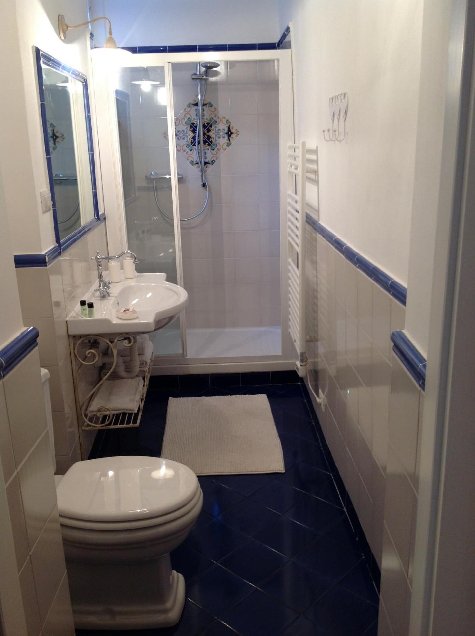 A compact bathroom with a toilet, sink, and shower.