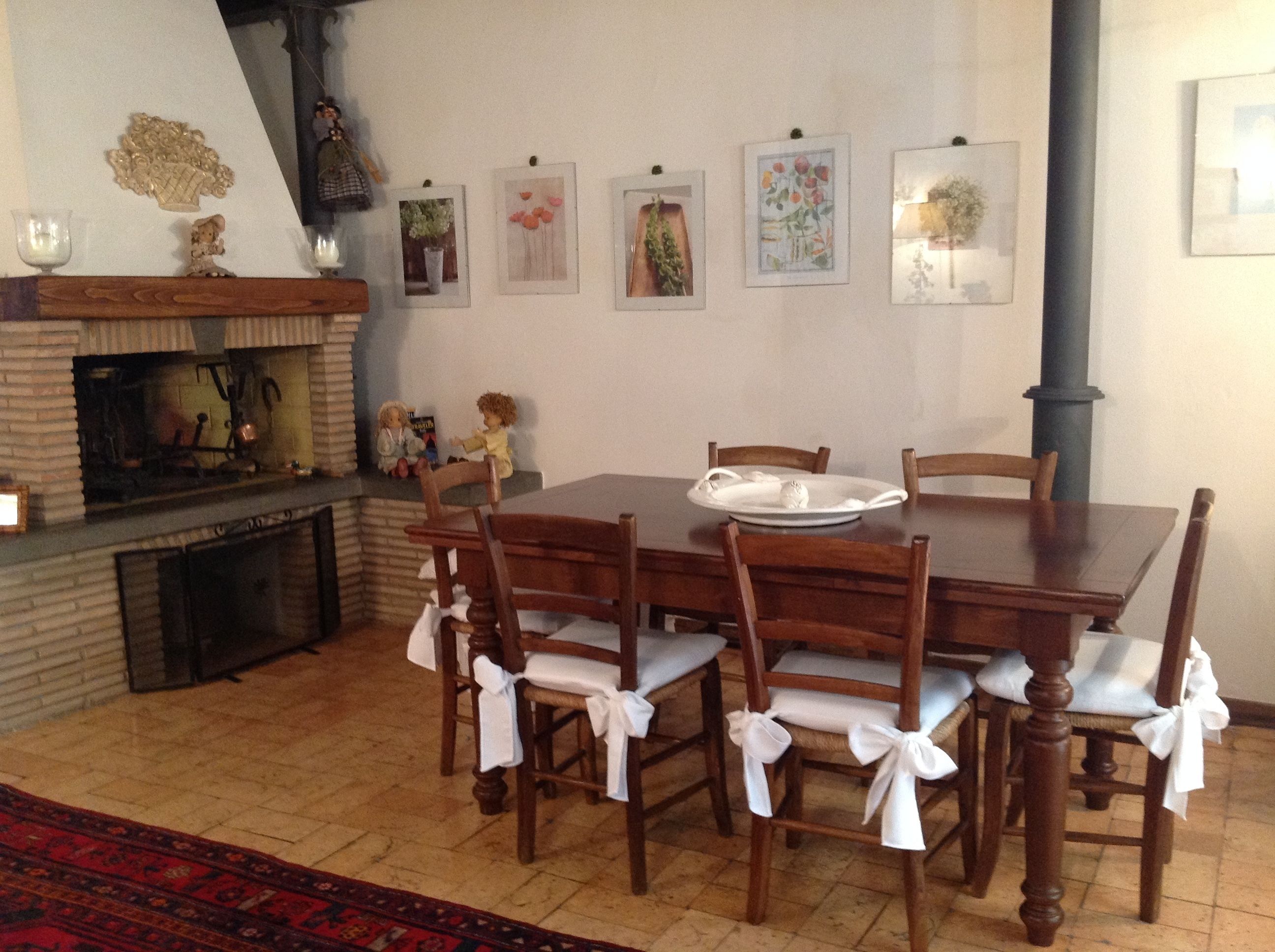 Comedor con mesa de madera, sillas y chimenea.