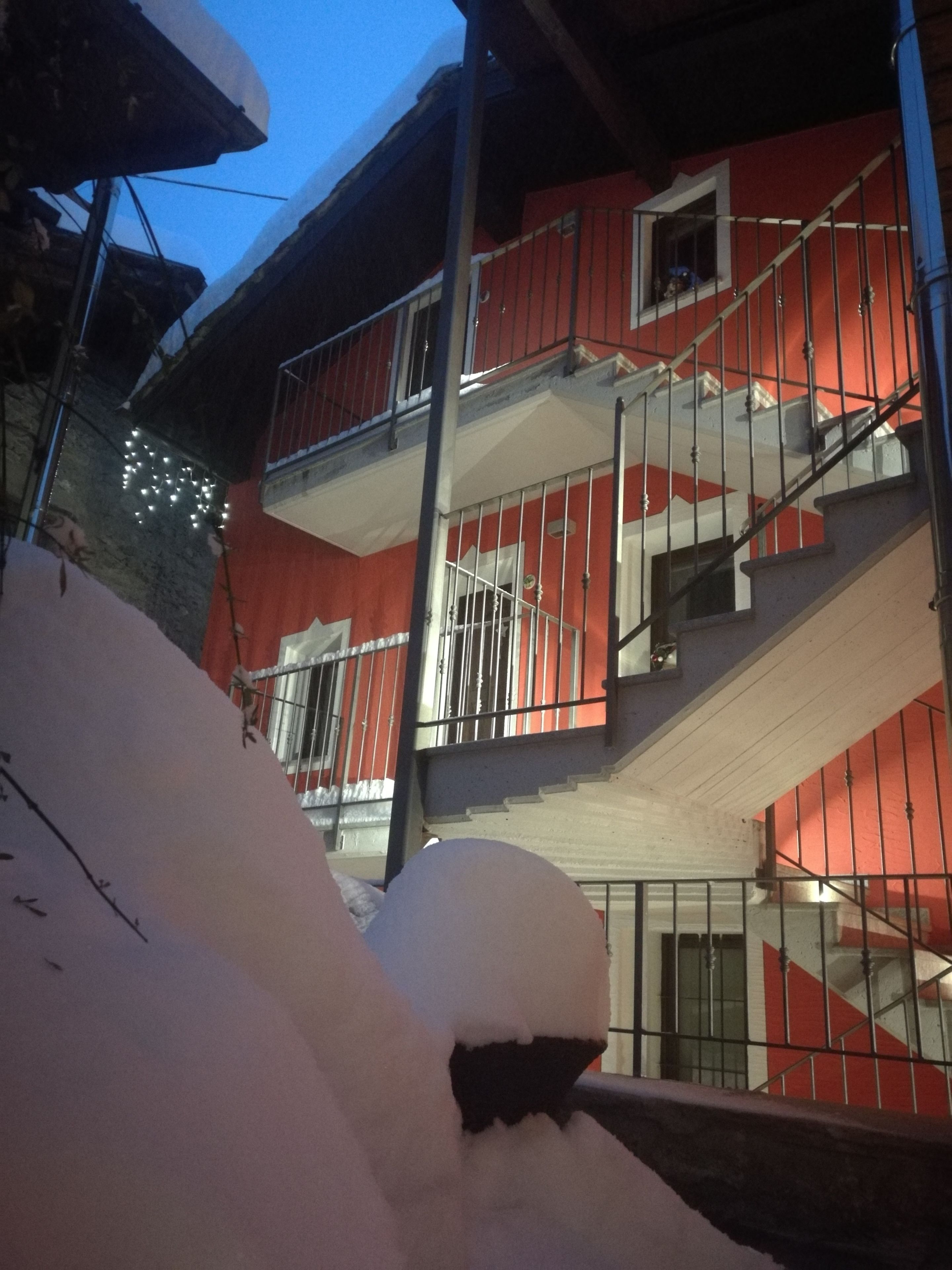 Ein mehrstöckiges Gebäude mit roter Fassade und weißen Geländern.
