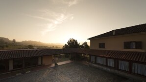 Une cour dallée, un espace de repos abrité et un bâtiment doté d’un toit en tuiles.