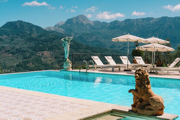 Piscine extérieure, parasols de plage, chaises longues