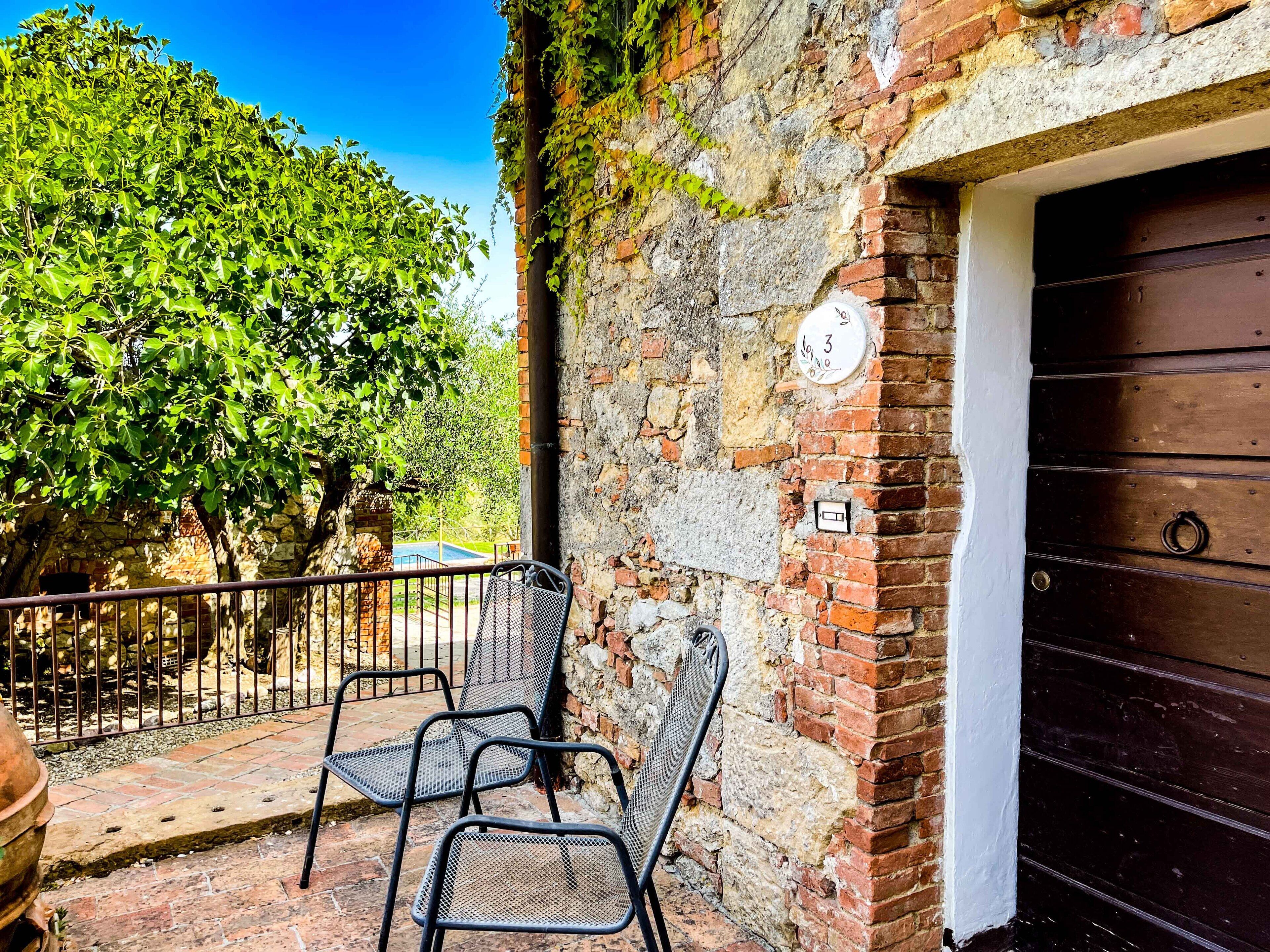 A rustic building with a brick exterior, a metal gate, and a wooden door.