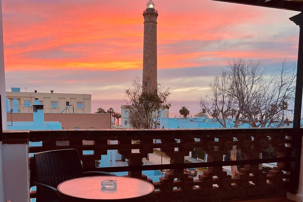 A terrace with a view of a tower and sunset.