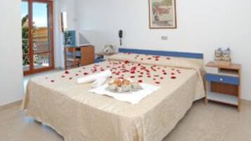 Une chambre à coucher avec un lit, une table de chevet, une petite table et une fenêtre.