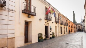 Una calle con edificios, banderas y un camino adoquinado.