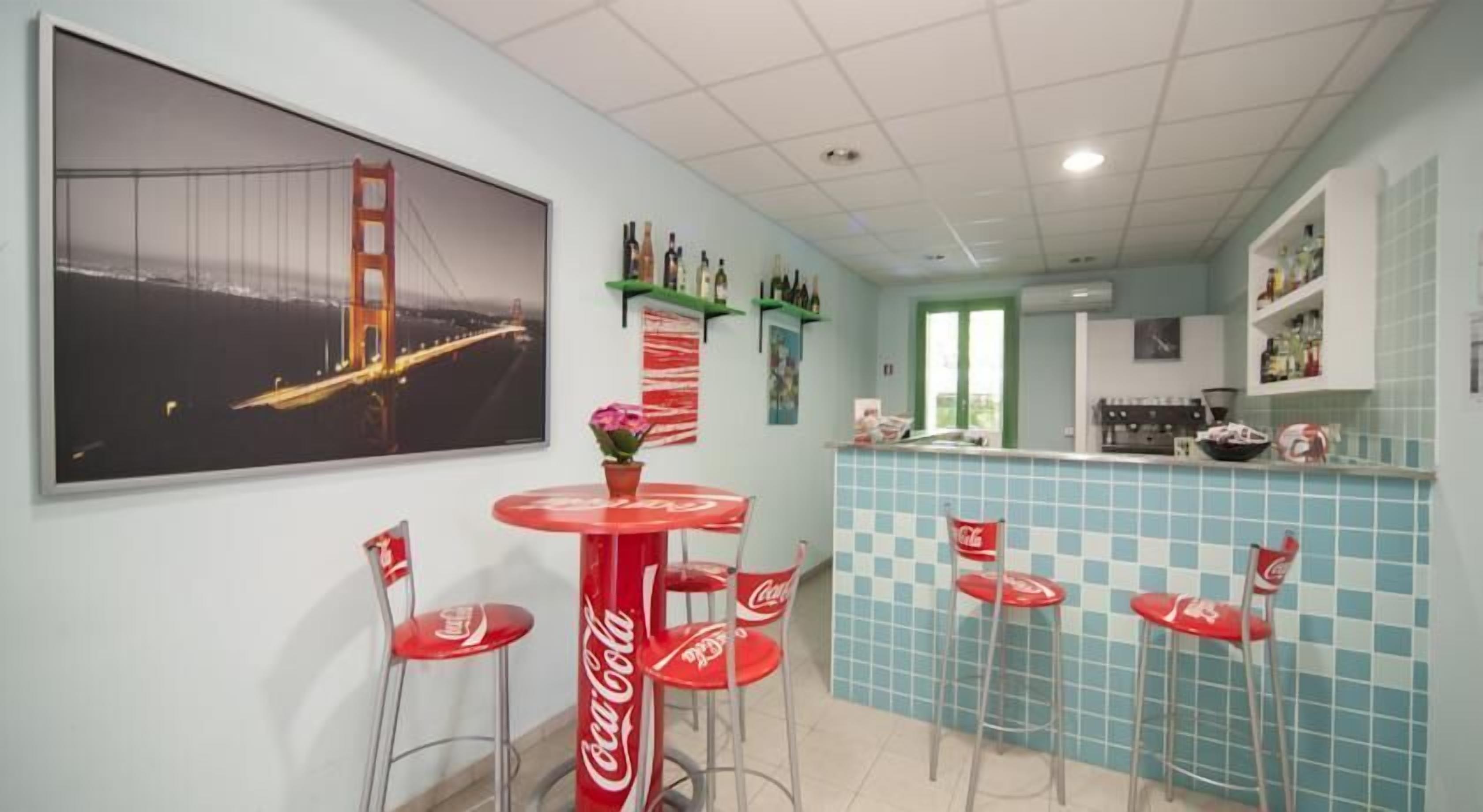 A kitchen with a tiled backsplash, a bar area with red bar stools, and a large framed picture of the Golden Gate Bridge.
