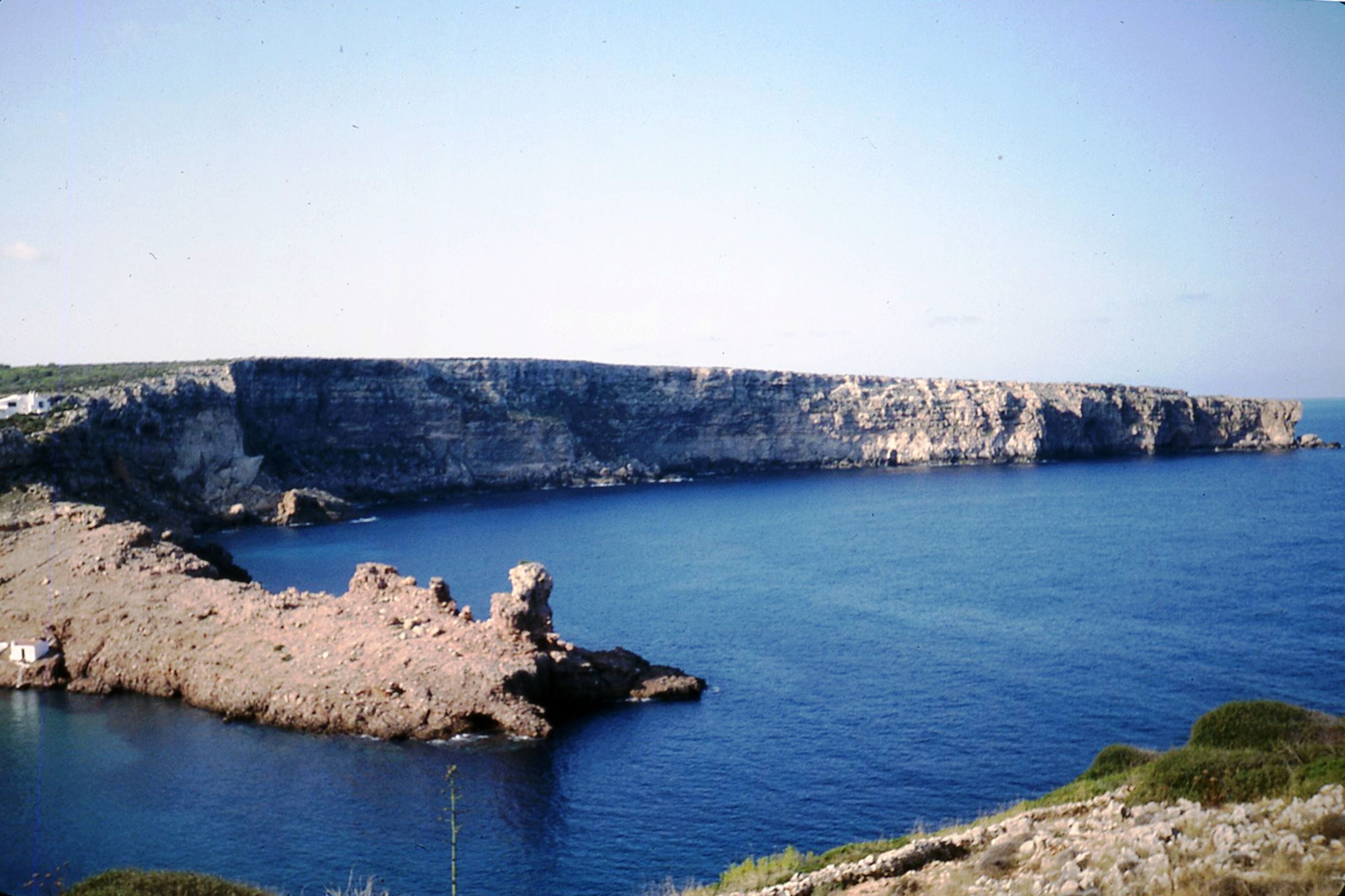 Un paisaje costero con acantilados rocosos y mar tranquilo.