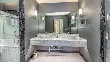 A modern bathroom with two sinks, a large mirror, and a shower area.