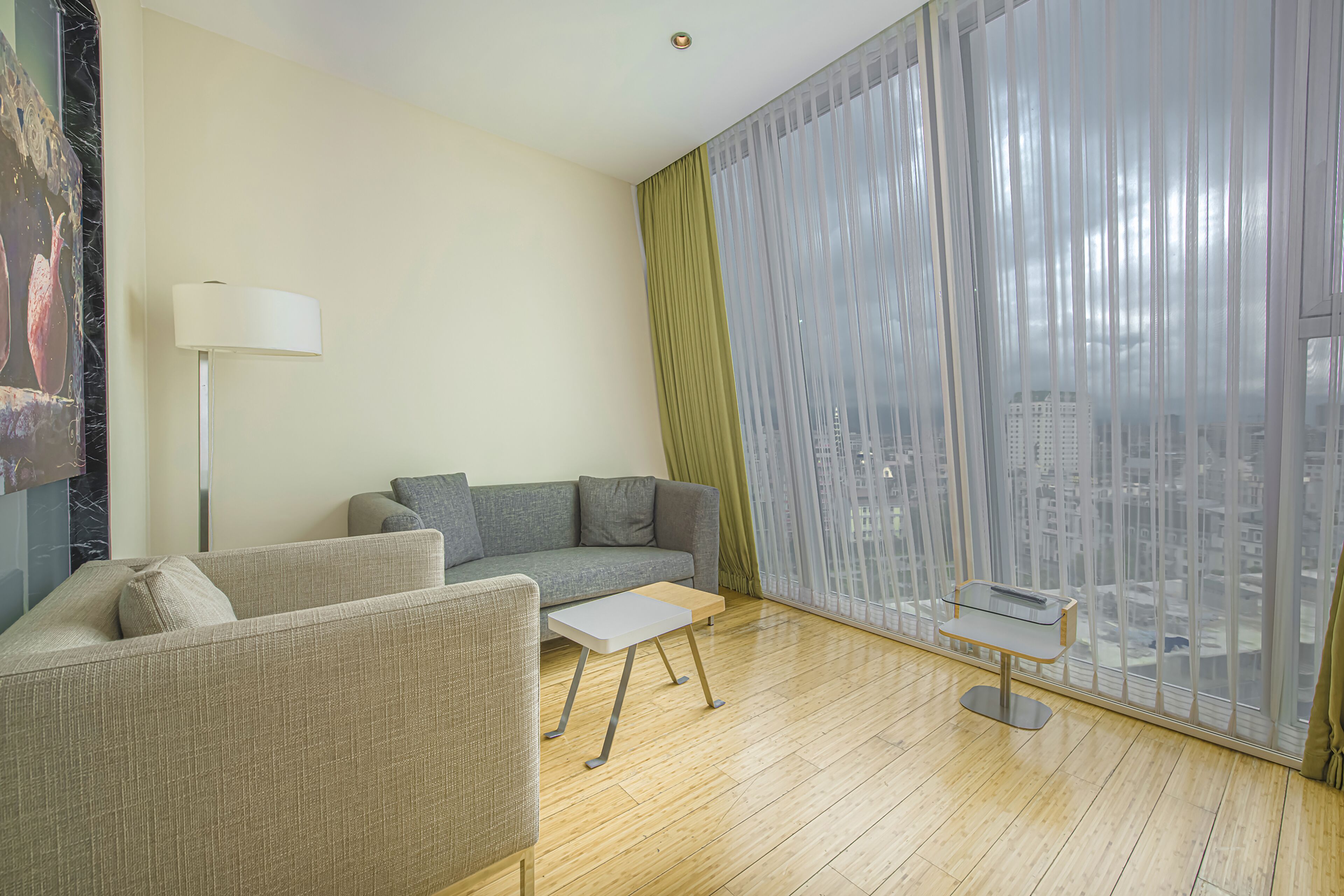 A modern living room with a sofa, a small table, and a floor lamp.