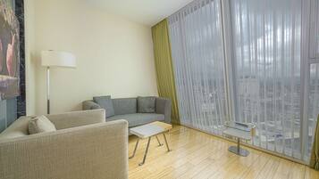 A modern living room with a sofa, a small table, and a floor lamp.
