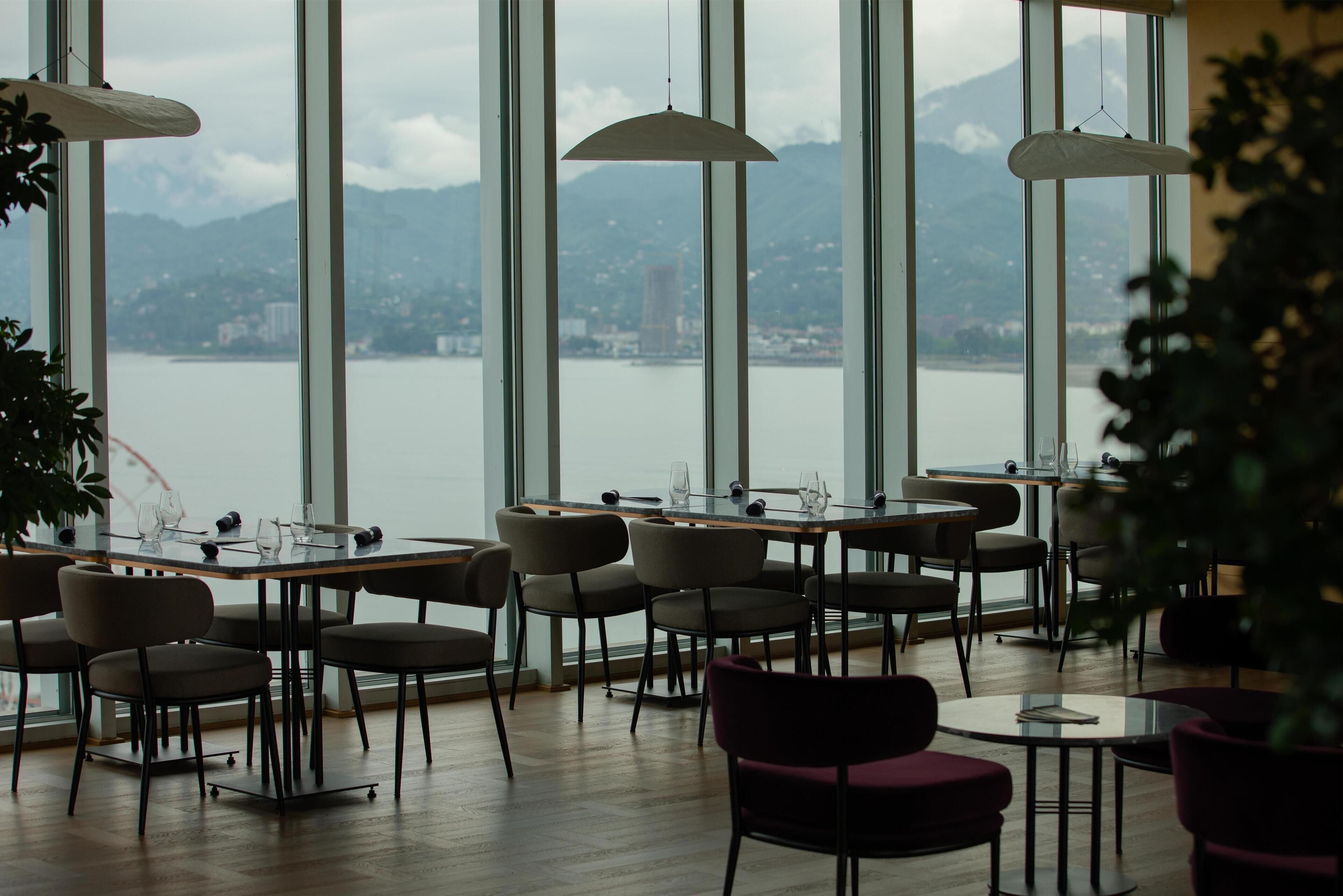 A restaurant with a view of a lake and mountains.