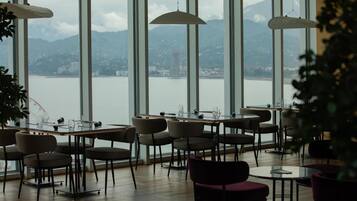 A restaurant with a view of a lake and mountains.