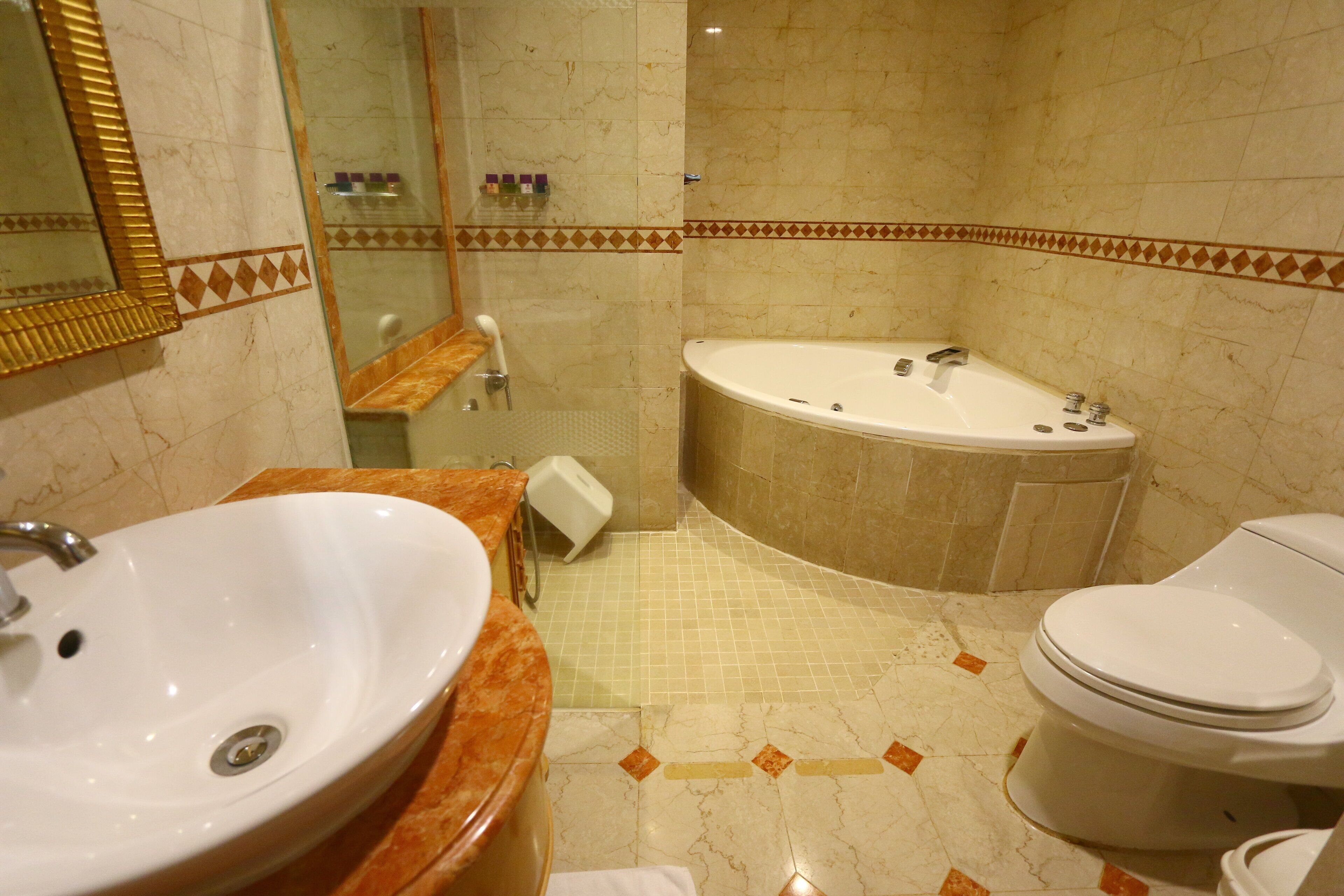 Un baño con lavamanos, inodoro y bañera.