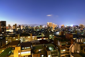 A cityscape at night with illuminated buildings and a clear sky.