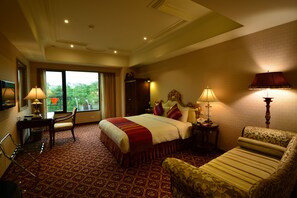 A hotel room with a large bed, a desk, a chair, and a sofa. - Rido Hotel (Taipei)