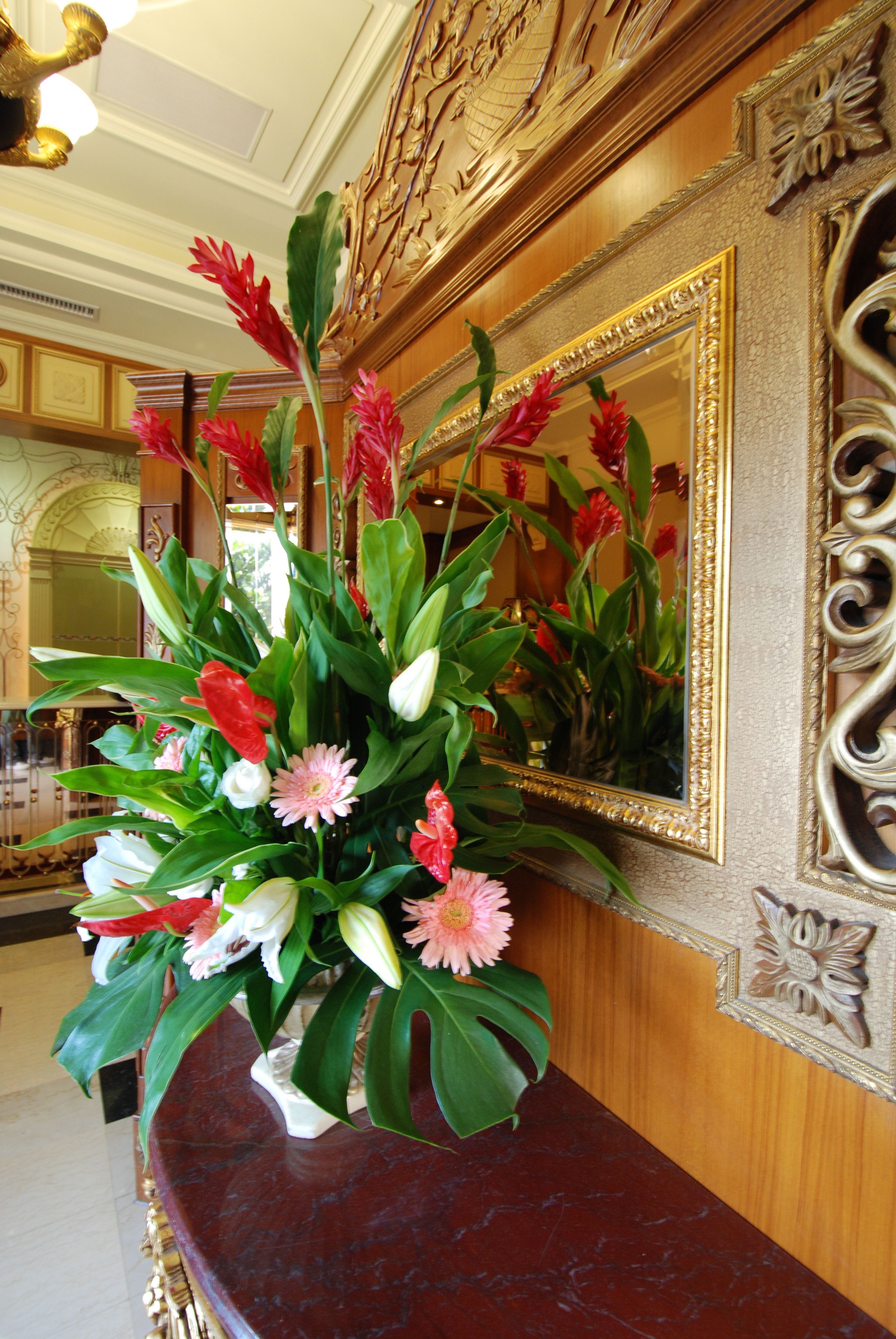 A marble reception desk with a floral arrangement.